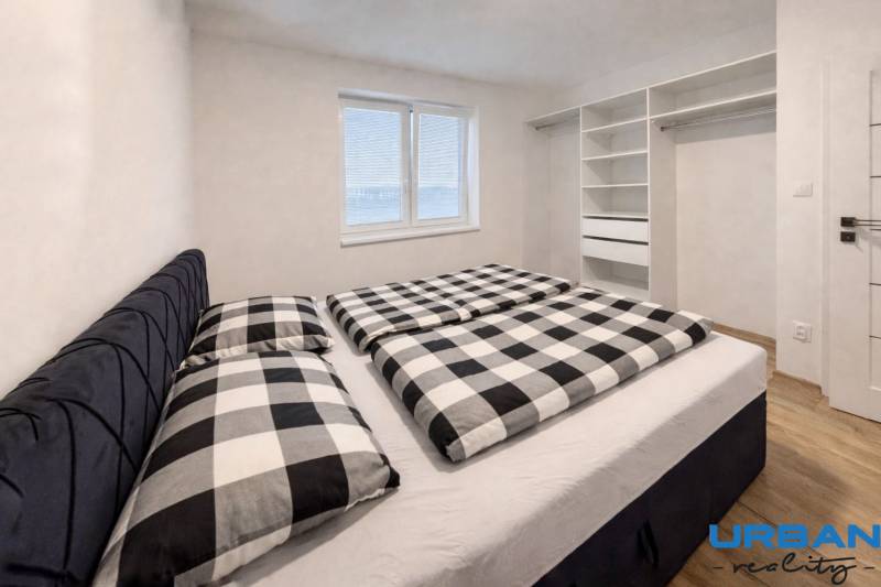 Moderný 3-izbový byt so záhradou Šamorín-Kráľovianky - Spálňa v 3-izbovom byte so vstavanou skriňou a podlahou s dreveným dekorom.