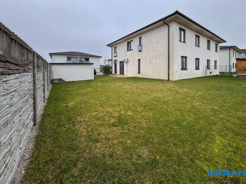 Moderný 3-izbový byt so záhradou Šamorín-Kráľovianky - Exteriér 3-izbového bytu na ulici Kráľovianky v Kráľoviankach s trávnikom a plotom.