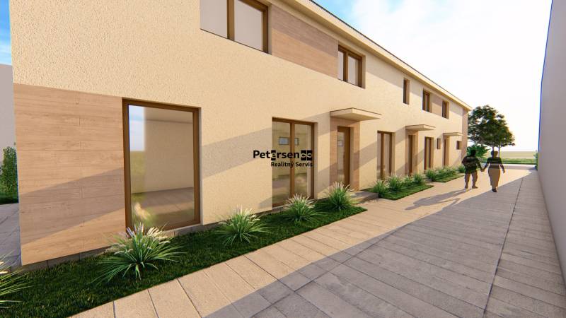 PREDPREDAJ – 3-izbový tehlový mezonet s garážou a pozemkom | Topoľčian - Rovná fasáda budovy s vysokými oknami a chodníkom na ulici Litoměřická v Topoľčiankach.