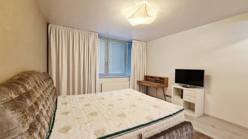 Luxusný 3-izb. byt s famóznym výhľadom na Dunaj, River Park - Spálňa v 3-izbovom byte s posteľou, televízorom a písacím stolom.