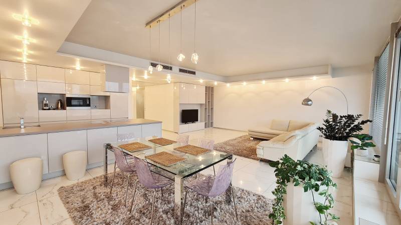 Luxusný 3-izb. byt s famóznym výhľadom na Dunaj, River Park - Priestranný interiér 3-izbového bytu s kuchyňou, jedálenským stolom a obývacou zónou.