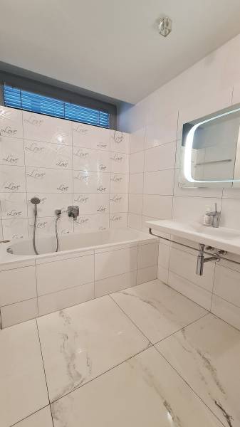 Luxusný 3-izb. byt s famóznym výhľadom na Dunaj, River Park - Kúpeľňa s vaňou a obkladačkami v 3-izbovom byte, biele a sivé farebné tónovanie.