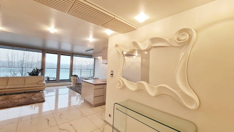 Luxusný 3-izb. byt s famóznym výhľadom na Dunaj, River Park - Luxusný interiér 3-izbového bytu s veľkými oknami a štýlovým zrkadlom.