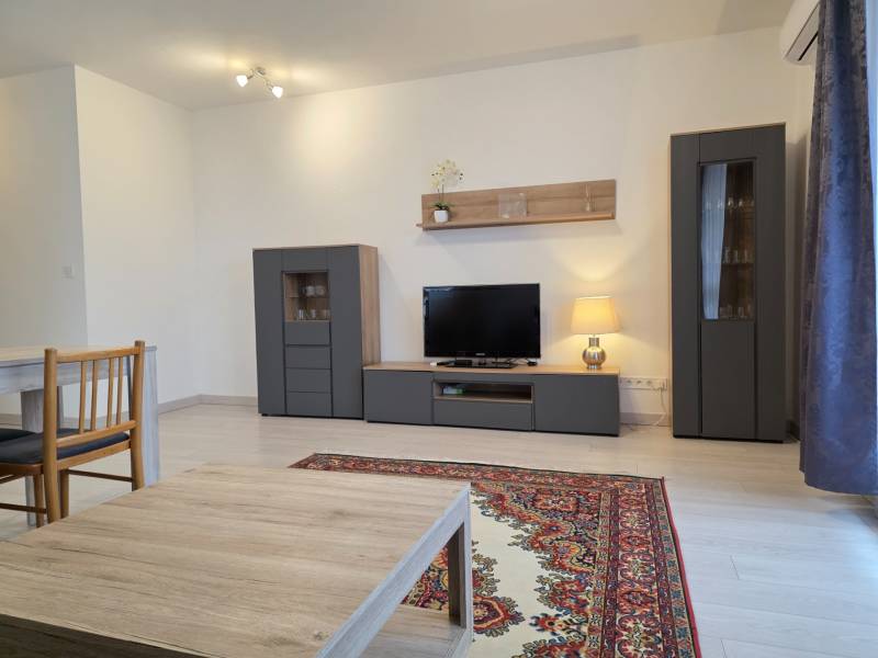 PREDAJ - 3 izbový byt blízko centra - Pivovarská ulica Nitra - Obývacia izba so sivým nábytkom a televízorom v 3-izbovom byte s podlahou s dreveným dekorom.