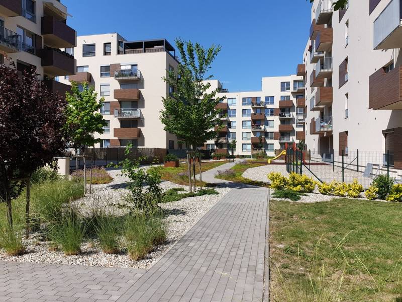 PREDAJ - 3 izbový byt blízko centra - Pivovarská ulica Nitra - Bytové domy na Pivovarskej ulici v Nitre, obklopené upravenou zeleňou a chodníkom.