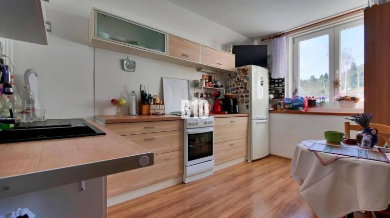 Praktický 8-izbový rodinný dom na Bystričke: Vhodný pre veľkú rodinu z - Kuchyňa v rodinnom dome s dreveným dekorom a výhľadom z okna.