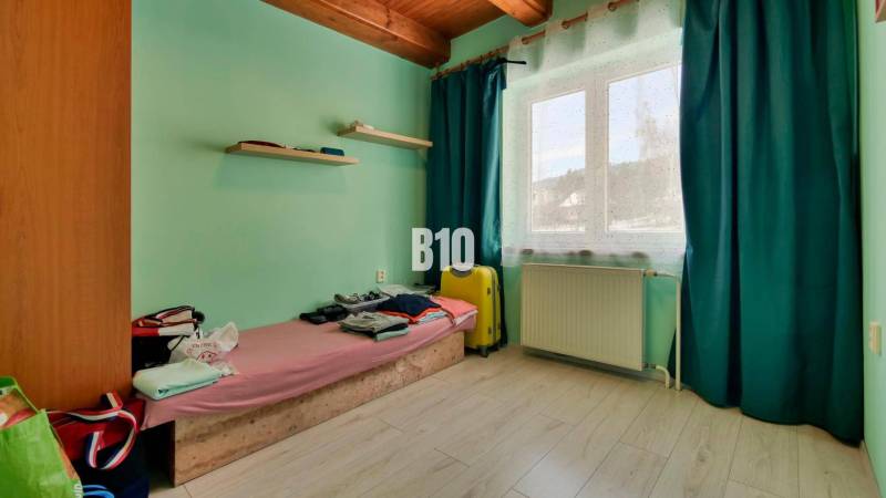 Praktický 8-izbový rodinný dom na Bystričke: Vhodný pre veľkú rodinu z - Izba v rodinnom dome so stenami v pastelových farbách a oknom so závesmi.