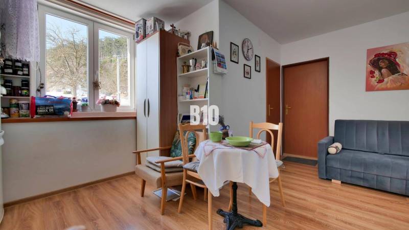 Praktický 8-izbový rodinný dom na Bystričke: Vhodný pre veľkú rodinu z - Interiér rodinného domu s podlahou s dreveným dekorom a útulným posedením pri stole.