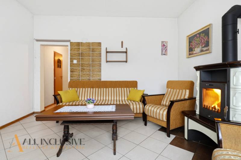 REZERVOVANÉ 4-izb. rodinný dom s garážou, Čierny Brod - Obývacia izba v rodinnom dome s krbom, pruhovanou sedačkou a konferenčným stolíkom.