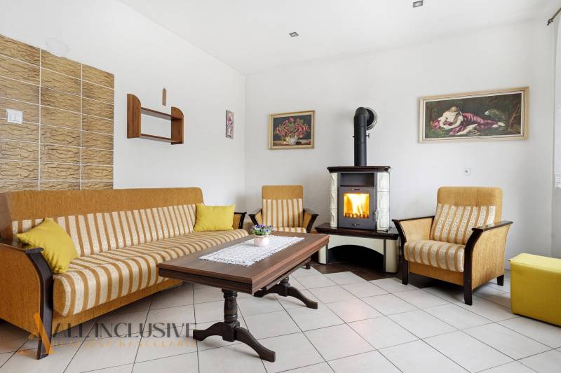 REZERVOVANÉ 4-izb. rodinný dom s garážou, Čierny Brod - Obývačka v rodinnom dome s krbom, pohovkou a dreveným stolom.