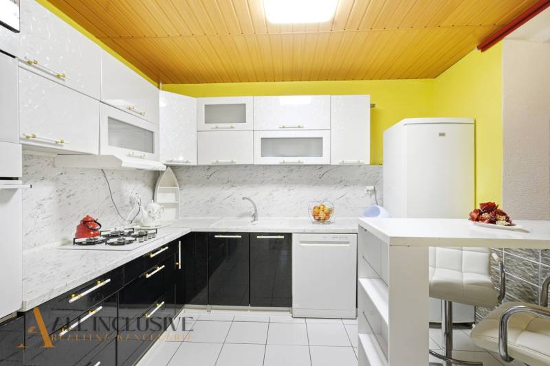 REZERVOVANÉ 4-izb. rodinný dom s garážou, Čierny Brod - Kuchyňa v rodinnom dome so svetlými skrinkami, mramorovým obkladom a bielymi spotrebičmi.