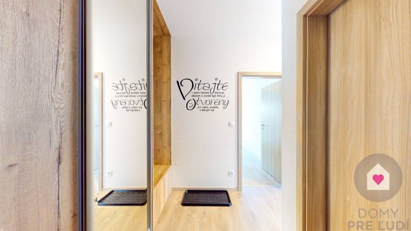 BA/PETRŽALKA-Prenájom moderného 3i bytu s parkovacím státim-Slnečnice - Vstupná chodba s podlahou s dreveným dekorom v 3-izbovom byte a nápisom na stene.