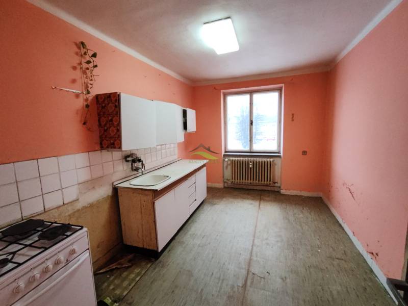 VEĽKÝ DVOJIZBOVÝ BYT 58M² + 2 PIVNICE, VRANOV - Kuchyňa v 2-izbovom byte s oranžovými stenami a jednoduchou kuchynskou linkou.