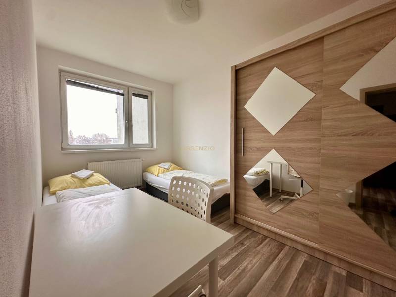 | PREDAJ | 3 izbový byt s veľkou loggiou – Banšelova, Ružinov - Spálňa s dvomi posteľami, bielym stolom a skriňou v 3-izbovom byte.