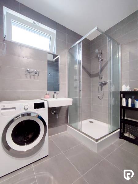 | 3-izbový byt v novostavbe, ul. Odevná + parking | Trenčín  - Kúpeľňa v 3-izbovom byte s práčkou, sprchovým kútom a umývadlom.