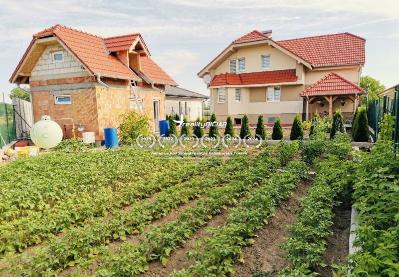 Moderný rodinný dom v Ratkovciach s priestrannou pivnicou - Rodinný dom v Ratkovciach s priestrannou záhradou plnou zeleniny a stromov.