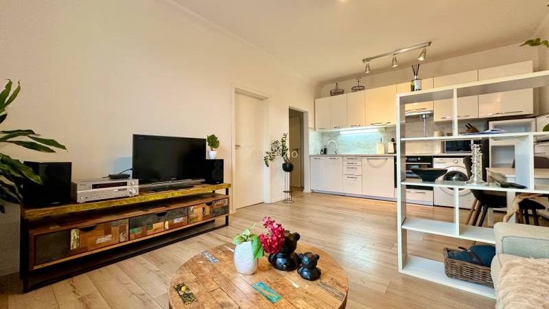 – PRENAJOM – 2 IZBOVÝ BYT 52 m² – OSTREDKOVA – RUŽINOV  - Obývačka v 2-izbovom byte s podlahou s dreveným dekorom, vkusne zariadená a útulná.