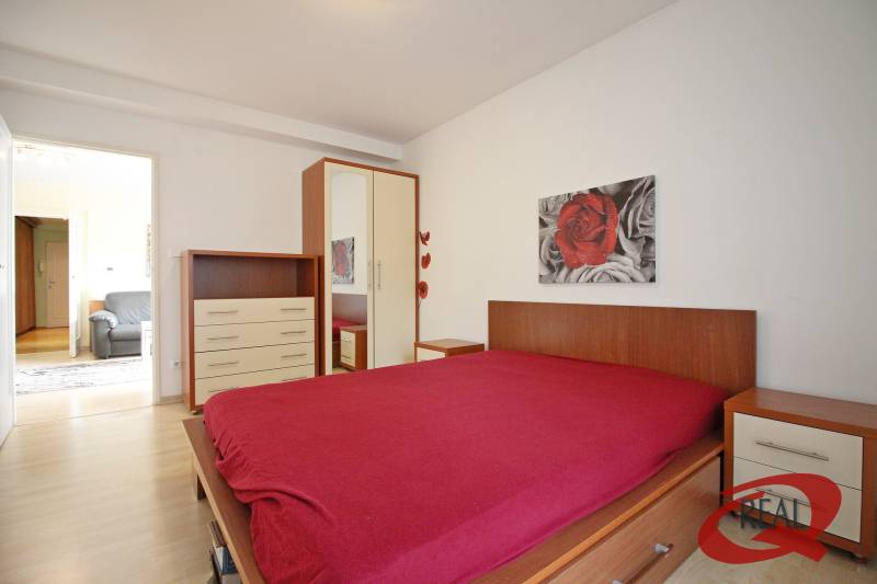 **BEZ PROVÍZIE**3-IZBOVÝ BYT S BALKÓNOM A LOGGIOU NA PALISÁDACH**      - Spálňa s podlahou s dreveným dekorom, posteľou, skrinkou a obrazom v 3-izbovom byte.