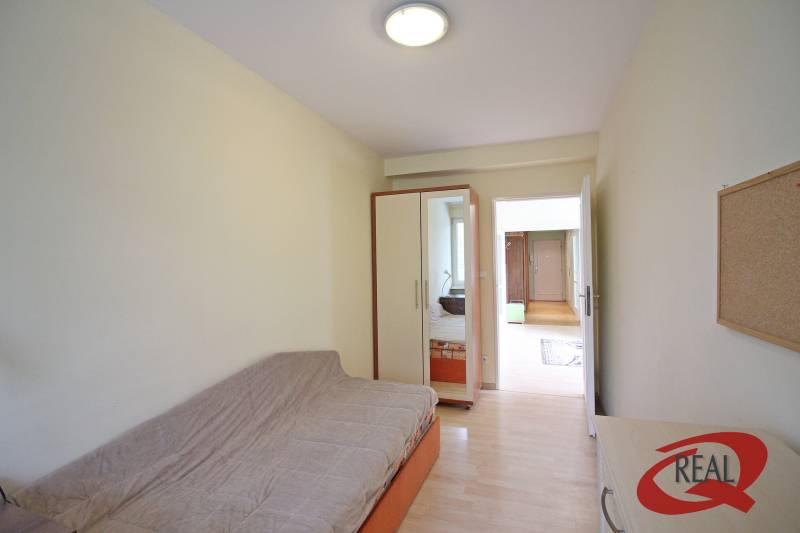 **BEZ PROVÍZIE**3-IZBOVÝ BYT S BALKÓNOM A LOGGIOU NA PALISÁDACH**      - Izba v 3-izbovom byte s pohovkou, vstavanou skriňou a podlahou s dreveným dekorom.