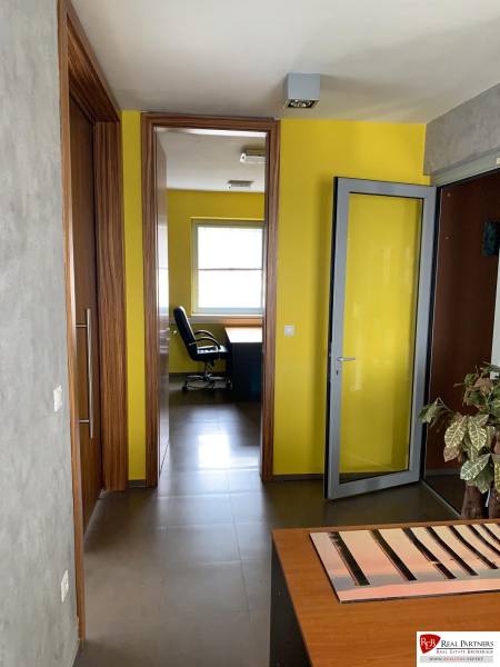 Predaj modernej administratívnej budovy v Bratislave, okres II - V kancelárii prevládajú žlté steny a drevené dvere, čo pôsobí útulne.