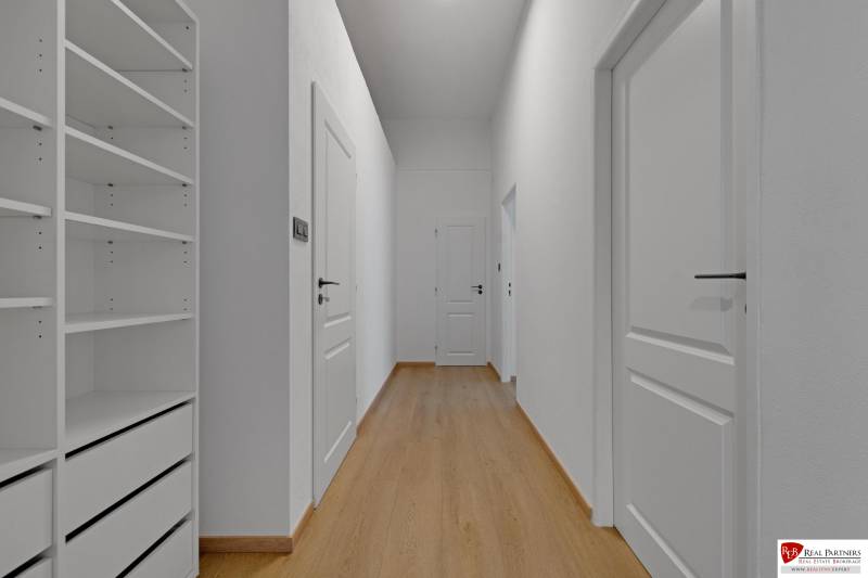 ,Prenájom moderný 3 izb. dom, Sološnícka ul,124 m2, Karlova Ves - Chodba v rodinnom dome s podlahou s dreveným dekorom a bielym nábytkom.