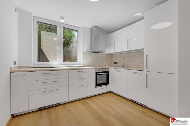 ,Prenájom moderný 3 izb. dom, Sološnícka ul,124 m2, Karlova Ves - Kuchyňa s bielymi skrinkami a podlahou s dreveným dekorom v rodinnom dome.