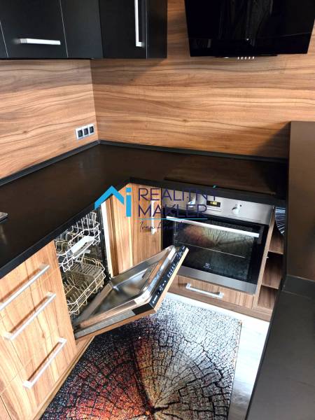 Prenajaté - 2.izbový byt s parkovaním v obci Hviezdoslavov - Kuchyňa v 1-izbovom byte so vstavanou umývačkou a dreveným dekorom.