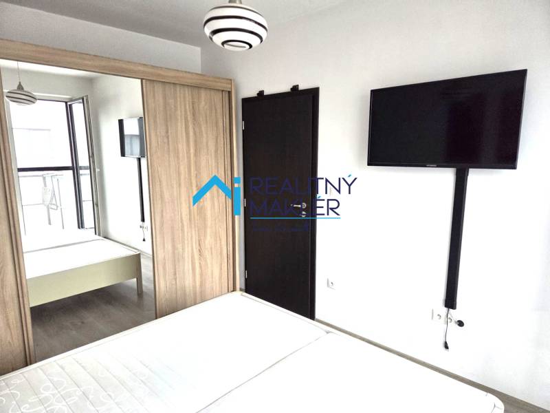 Prenajaté - 2.izbový byt s parkovaním v obci Hviezdoslavov - Spálňa s televízorom, šatníkovou skriňou a drevenými dverami v 1-izbovom byte.