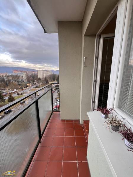 Prenájom: 2 izbový byt Žilina - Vlčince - Balkón 2-izbového bytu v Žiline s keramickou dlažbou a výhľadom na okolité budovy.