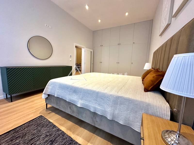 Prenájom priestranného 2-izbového bytu v absolútnom centre Košíc - Spálňa v 2-izbovom byte s posteľou, skriňami a podlahou s dreveným dekorom.