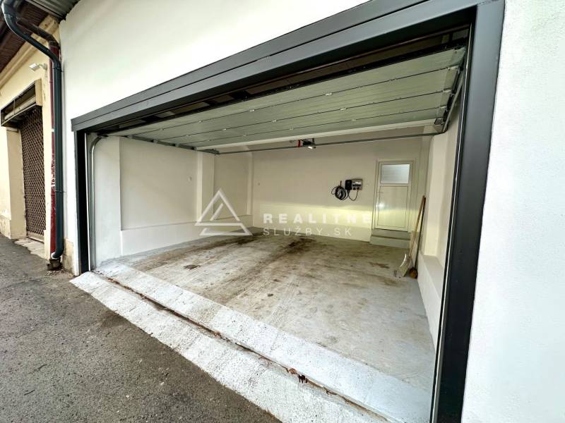 Prenájom priestranného 2-izbového bytu v absolútnom centre Košíc - Otvorená garáž na Mäsiarskej ulici v Košiciach, Staré Mesto, s bielymi stenami.