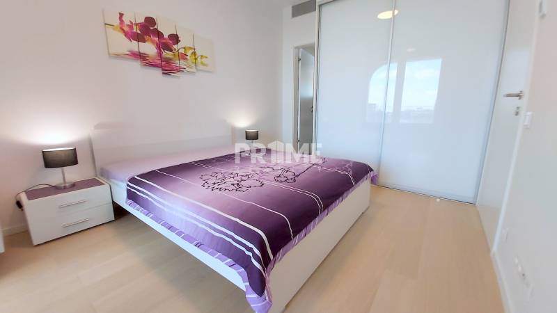 JEDINEČNÝ 2i byt, NOVOSTAVBA, KLÍMA, VÝHĽAD, PARKING, SKY PARK - Spálňa v 2-izbovom byte s podlahou s dreveným dekorom a veľkou posteľou.