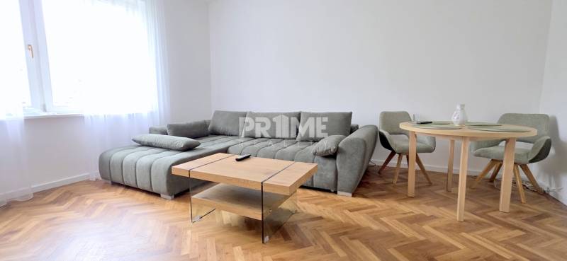 Pekný 3i byt, REKONŠTRUKCIA, KLÍMA, NIVY, Trenčianska ulica - Obývačka 3-izbového bytu ukazuje pohodlnú sedačku, stôl s kreslami na Trenčianskej ulici.