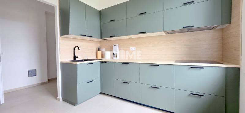 Pekný 3i byt, REKONŠTRUKCIA, KLÍMA, NIVY, Trenčianska ulica - Kuchyňa s dreveným obkladom a zelenými skrinkami na ulici Trenčianska v 3-izbovom byte.