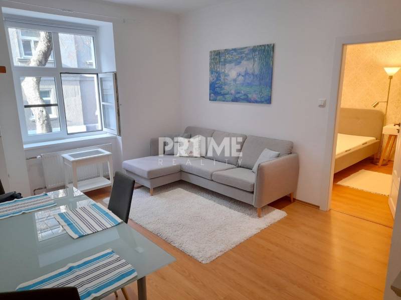 Pekný 2i byt, REKONŠTRUKCIA, CENTRUM, Bukureštská ulica, Staré Mesto - Obývacia izba 2-izbového bytu na ulici Bukurešťská s pohovkou a jedálenským stolom.