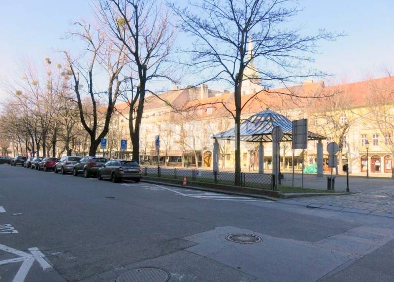 JEDINEČNÝ 2i byt, REKONŠT., 2 X .SAMOST.IZBA, Hviezdoslavovo nám.  - Na Hviezdoslavovo námestie sú stromy, parkujúce autá a historické budovy v pozadí.