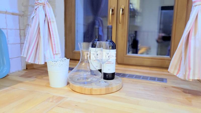 JEDINEČNÝ 2i byt, REKONŠT., 2 X .SAMOST.IZBA, Hviezdoslavovo nám.  - Na obrázku sú dve fľaše vína a pohár na drevenej doske.