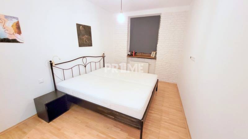 JEDINEČNÝ 2i byt, REKONŠT., 2 X .SAMOST.IZBA, Hviezdoslavovo nám.  - Spálňa s kovovou posteľou, bielymi stenami a dekoratívnymi obrazmi vedľa okna.