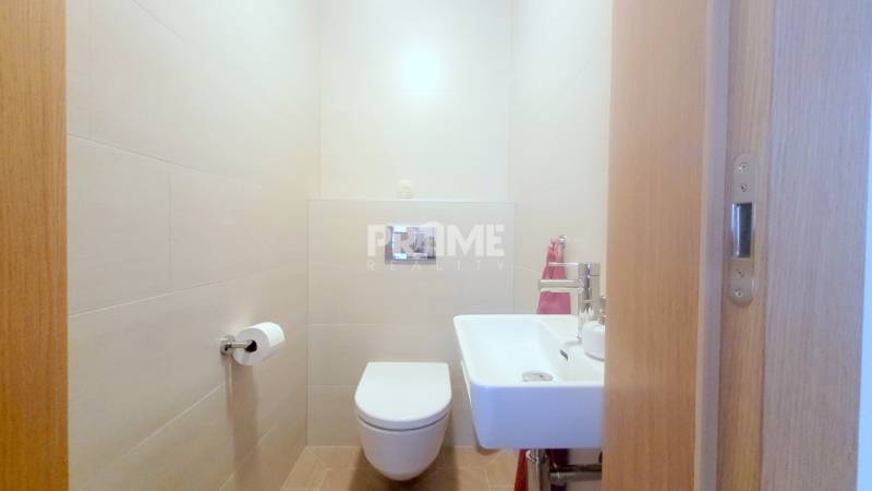 MODERNÝ 3i byt, CUBICON GARDENS, BALKÓN, PARKING, Rudolfa Mocka - Toaleta s umývadlom v 3-izbovom byte, neutrálne obklady a podlaha s dreveným dekorom.