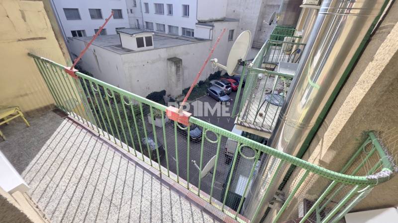 JEDINEČNÝ 2i byt, REKONŠTRUKCIA, 2 x BALKÓN, Kúpeľná ulica,Staré Mesto - Balkón s kovovým zábradlím, dvor so zaparkovanými autami, pohľad zo staršieho 2-izbového bytu.