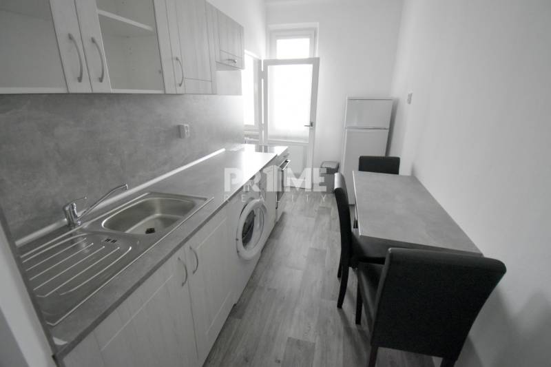 Pekný 3i byt, 3 x NEPRIECH.IZBA, BALKÓN, Radarová ulica, Ostredky - Kuchyňa v 3-izbovom byte s podlahou s dreveným dekorom, umývadlom a jedálenským stolom.