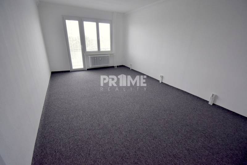 Pekný 3i byt, 3 x NEPRIECH.IZBA, BALKÓN, Radarová ulica, Ostredky - Priestranná miestnosť v 3-izbovom byte s veľkým oknom a tmavým kobercovým povrchom.