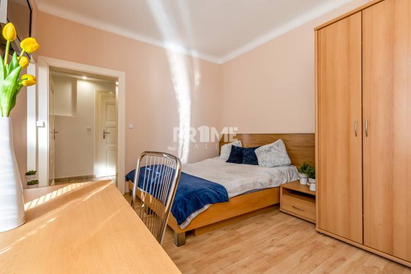 Pekná Garsónka, CENTRUM, REKONŠTRUKCIA,Vajanského nábrežie,Staré Mesto - Garsónka s podlahou s dreveným dekorom, posteľou a šatníkovou skriňou, zdobená kvetmi.