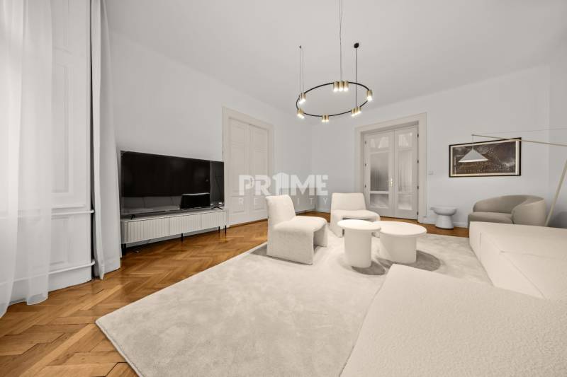  EXKLUZÍVNY, VEĽKOMETRÁŽNY 3i byt ( 130 m2 ), REKONŠTRUKCIA, CENTRUM - Obývacia izba v 3-izbovom byte s podlahou s dreveným dekorom a pohodlnými kreslami.