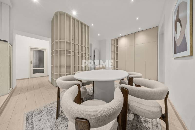  EXKLUZÍVNY, VEĽKOMETRÁŽNY 3i byt ( 130 m2 ), REKONŠTRUKCIA, CENTRUM - Interiér 3-izbového bytu s podlahou s dreveným dekorom, okrúhlym stolom a stoličkami.