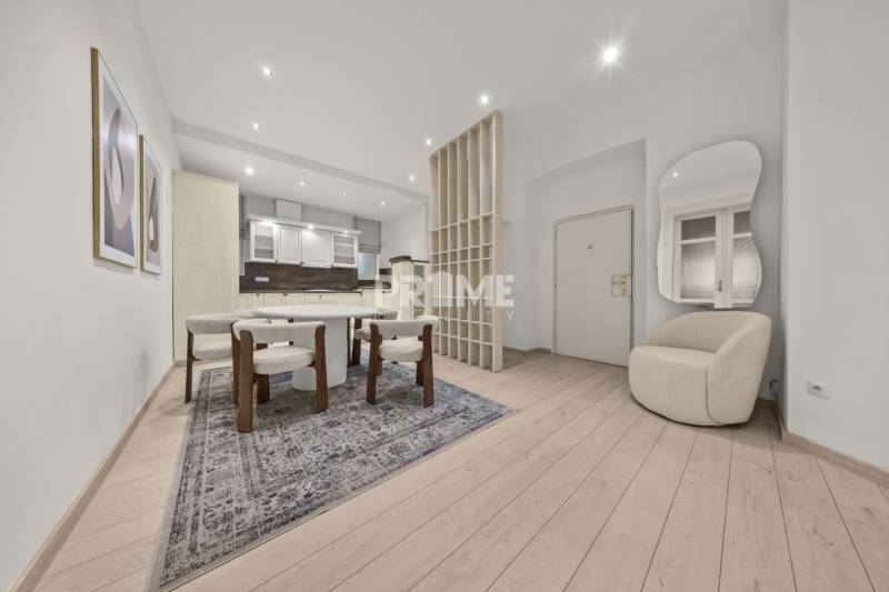  EXKLUZÍVNY, VEĽKOMETRÁŽNY 3i byt ( 130 m2 ), REKONŠTRUKCIA, CENTRUM - Interiér 3-izbového bytu s jedálenským stolom, kreslom a podlahou s dreveným dekorom.