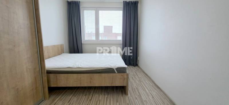 MODERNÝ 2i byt, REKONŠTRUKCIA, KLÍMA, MOZARTOVA ulica, Horský park - Svetlá spálňa v 2-izbovom byte s dreveným dekorom podlahy a veľkým oknom.