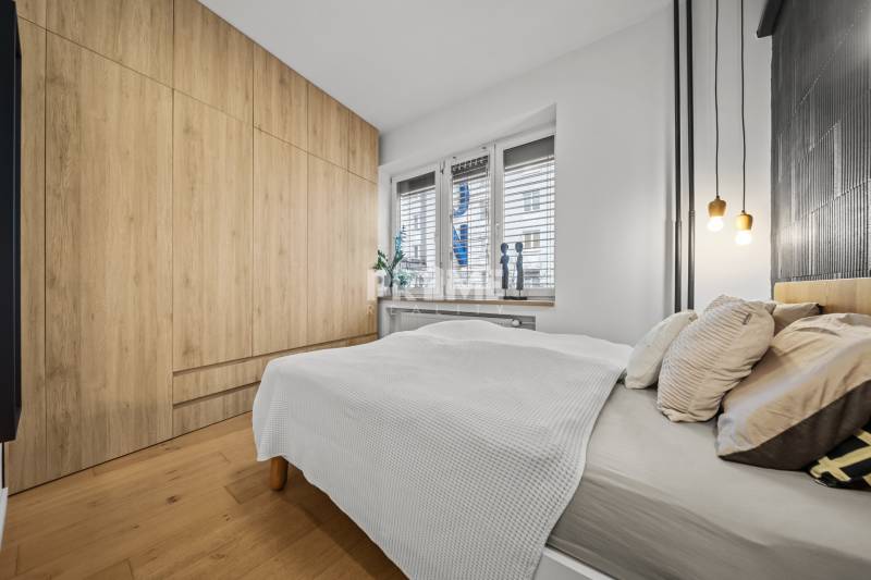 ŠTÝLOVÝ 3i byt, REKONŠTRUKCIA, Mýtna ulica, Staré Mesto - Spálňa v 3-izbovom byte s posteľou, vstavanou skriňou a podlahou s dreveným dekorom.