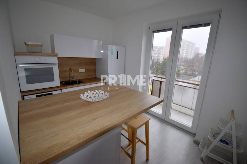 SLNEČNÝ 2i byt, REKONŠTRUKCIA, 2 X SAMOST.IZBA, BALKÓN, Haburská ulica - Kuchyňa v 2-izbovom byte s podlahou s dreveným dekorom a balkónovými dverami.