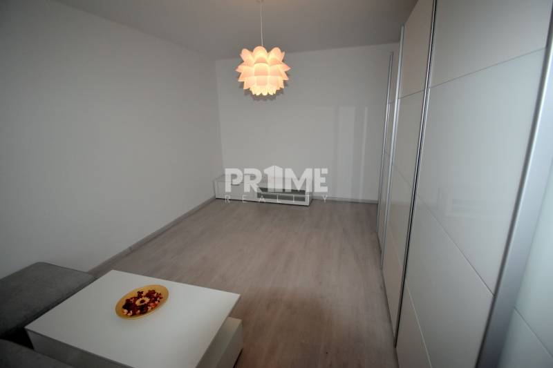 SLNEČNÝ 2i byt, REKONŠTRUKCIA, 2 X SAMOST.IZBA, BALKÓN, Haburská ulica - Obývacia izba v 2-izbovom byte s podlahou s dreveným dekorom a výrazným svietidlom.